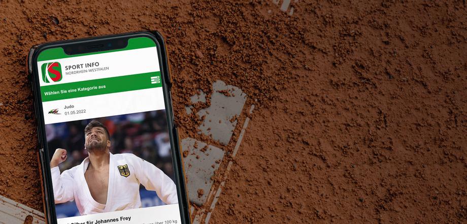 Smartphone auf erdigem Untergrund zeigt Artikel über Judosport und EM-Silber für Johannes Frey.